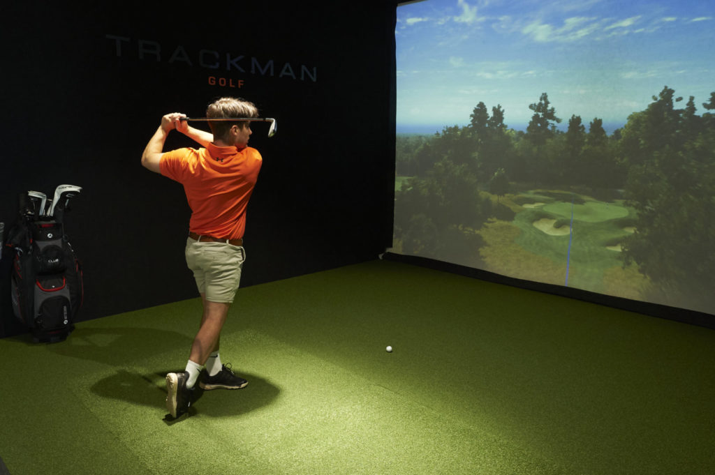 guy practising golf swing using a golf simulator at mattishall golf club