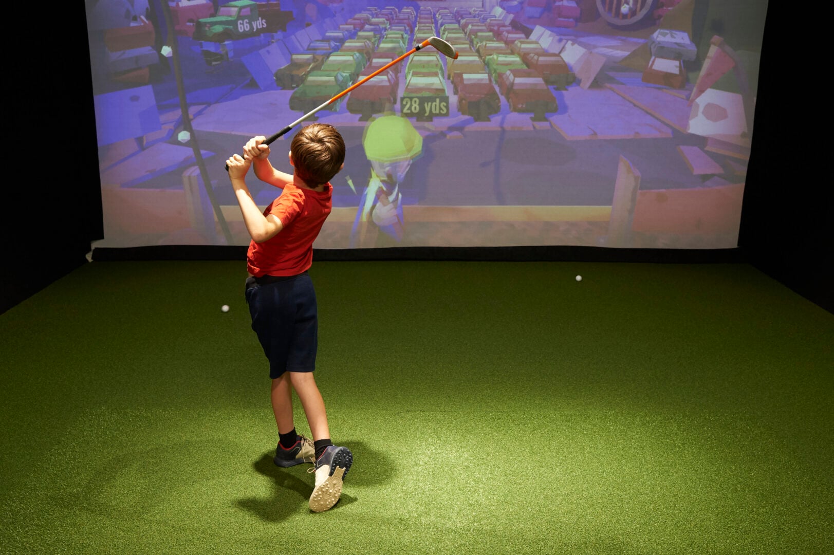 kid swinging golf club at golf simulator mattishall gold club